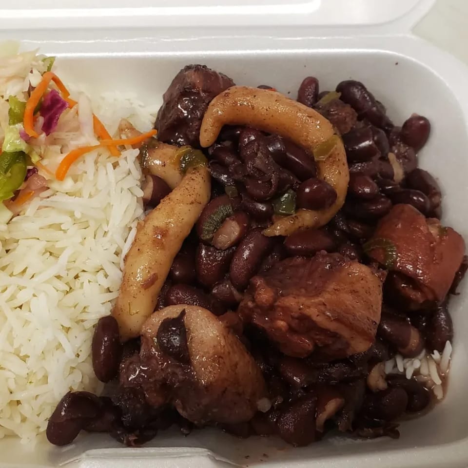 Topnotch Island Flavor Kitchen's Jamaican meal with rice, beans, meat, plantains, and coleslaw in a takeout container.